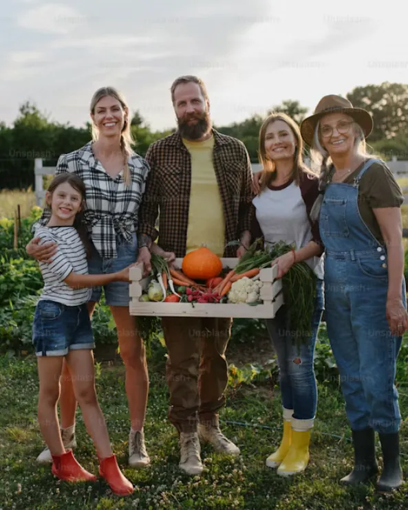 Una famiglia nell’orto con una cassetta di verdure appena raccolte